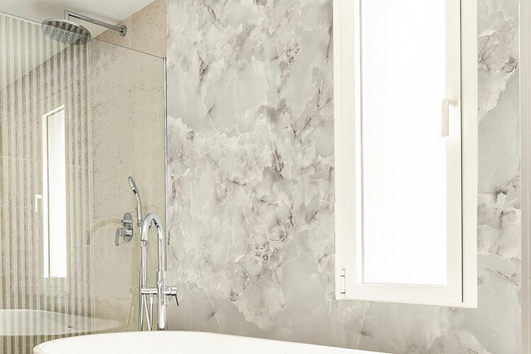 Salle de bain décorée avec du papier peint autocollant au motif de marbre blanc